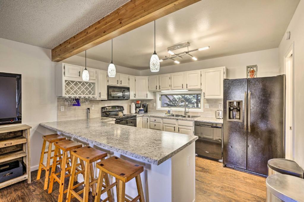 a kitchen with white cabinets and a large island with bar stools at Hot Tub and Mtn Views Silverthorne Escape! in Silverthorne