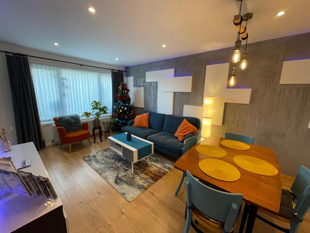 a living room with a table and a couch at Blarmore Apartment Inverness in Inverness