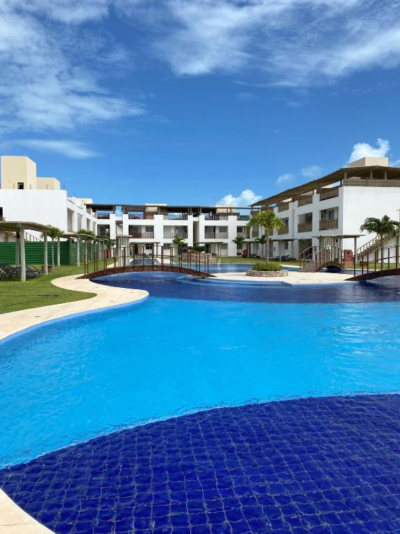 a large blue swimming pool in front of a building at Boas Vistas Canoa Quebrada in Aracati