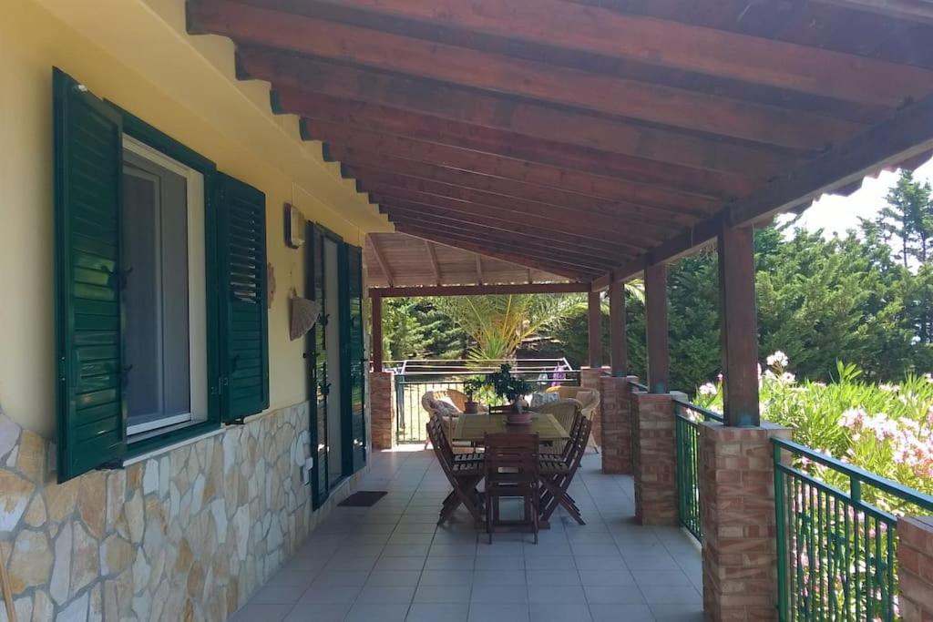 a patio with a table and chairs under a wooden pergola at Villa il Carrubo in Licata
