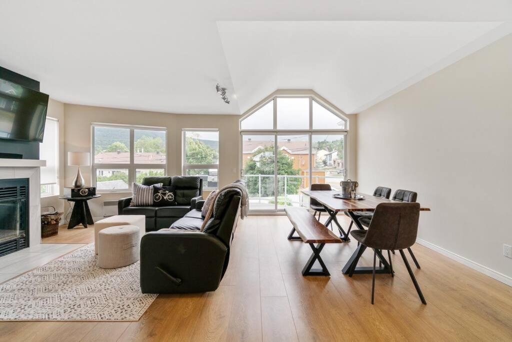 una sala de estar con un sofá y una mesa en INITIAL - La Charmante - MSA - Piscine privée, en Saint-Férréol-les-Neiges