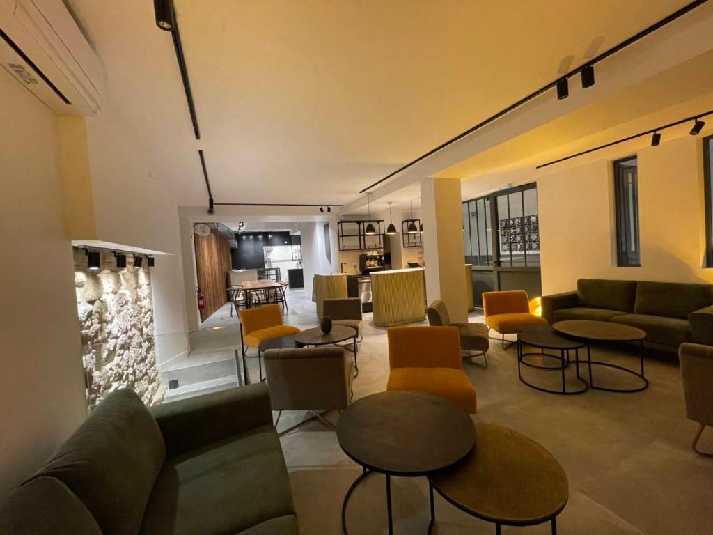 a living room with couches and tables and chairs at Appart Hôtel Victoria in Vincennes