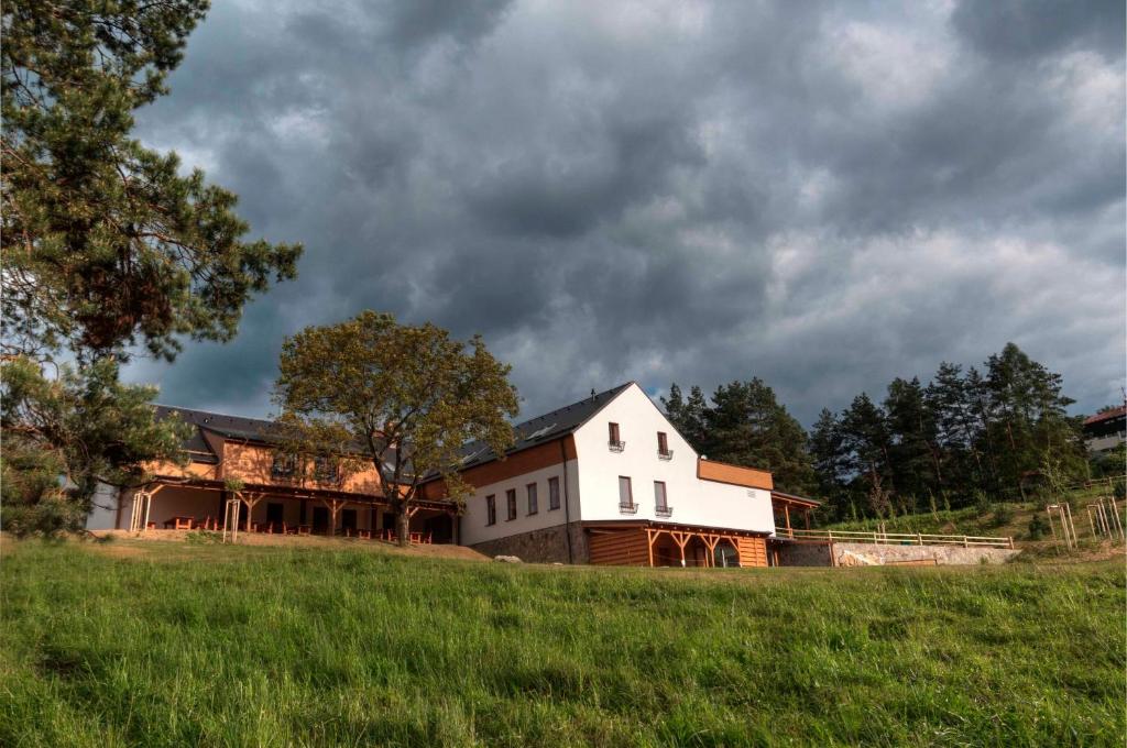 a large white barn on a hill in a field at Statek Samsara in Blansko