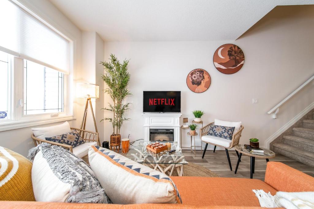 sala de estar con sofá y TV en Bali Style Home - King Bed - Fireplace - Jacuzzi - Fast Wi-Fi - Free Netflix & Garage Parking, en Edmonton