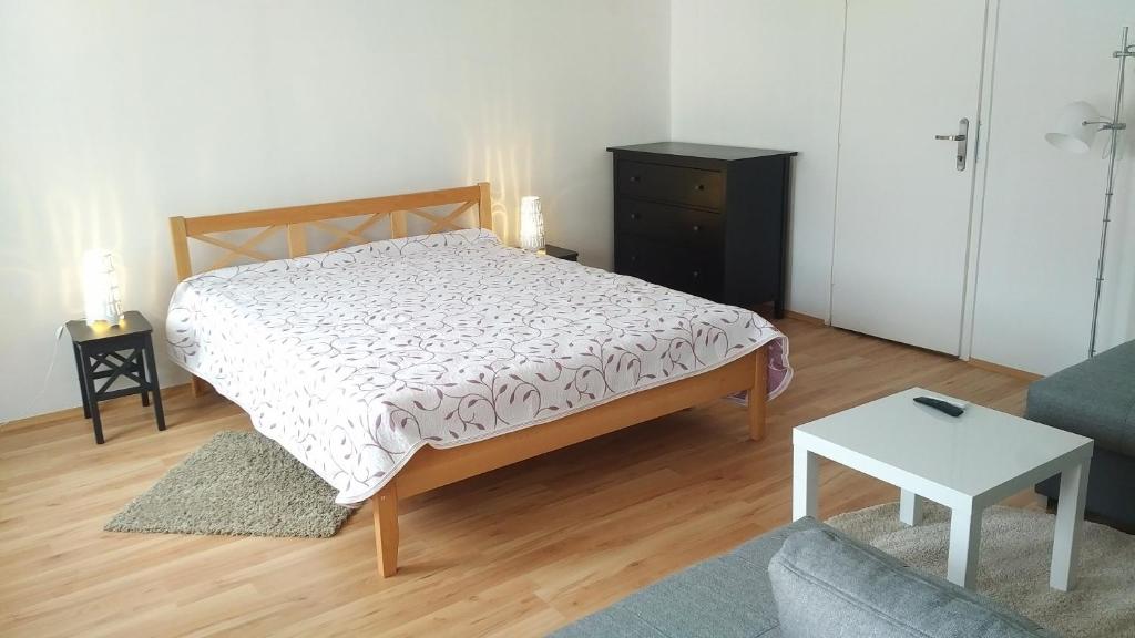 a bedroom with a bed and a couch and a table at FSQH SECRET TOWER in Szeged