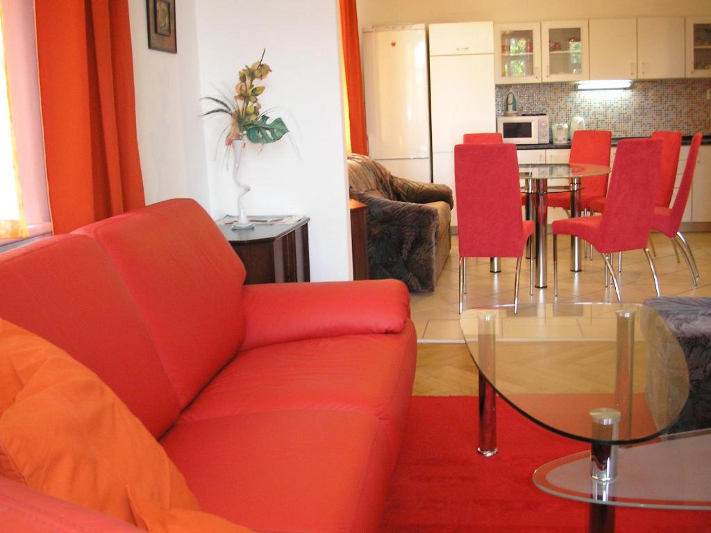 a living room with a red couch and a table at Apartment Riverside - River View in Bratislava
