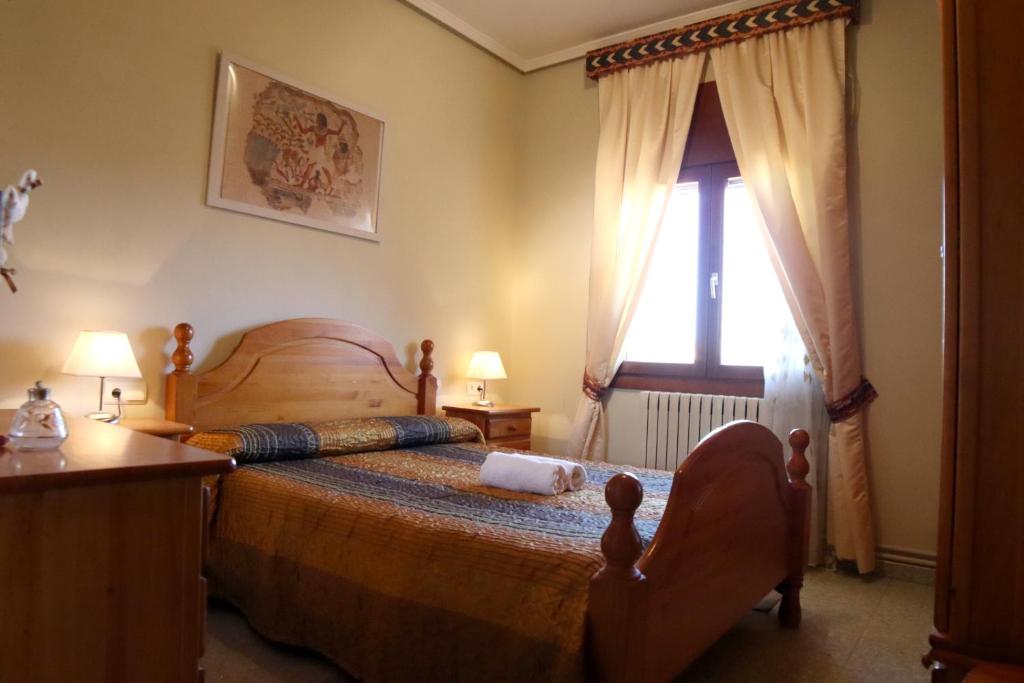a bedroom with a large bed and a window at Alojamiento Rural Ribaforada in Ribaforada
