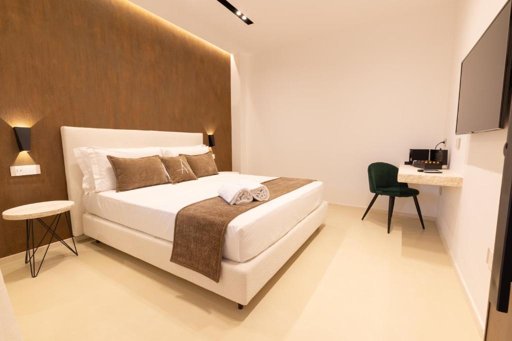 a bedroom with a white bed and a desk at Double A Luxury Room in Olbia