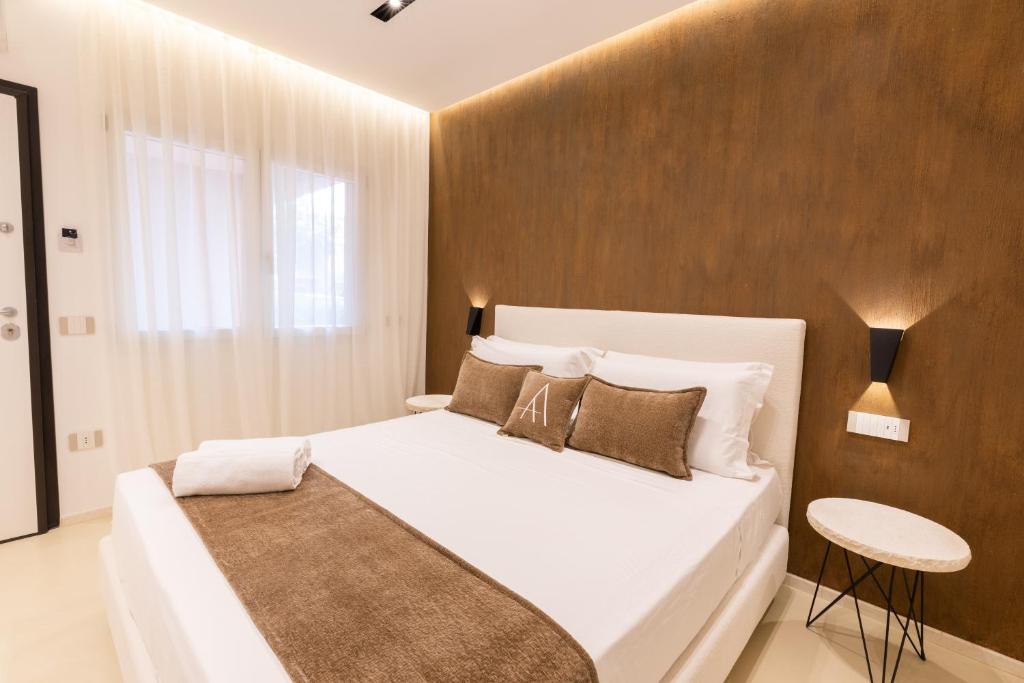 a bedroom with a white bed and a wooden wall at Double A Luxury Room in Olbia