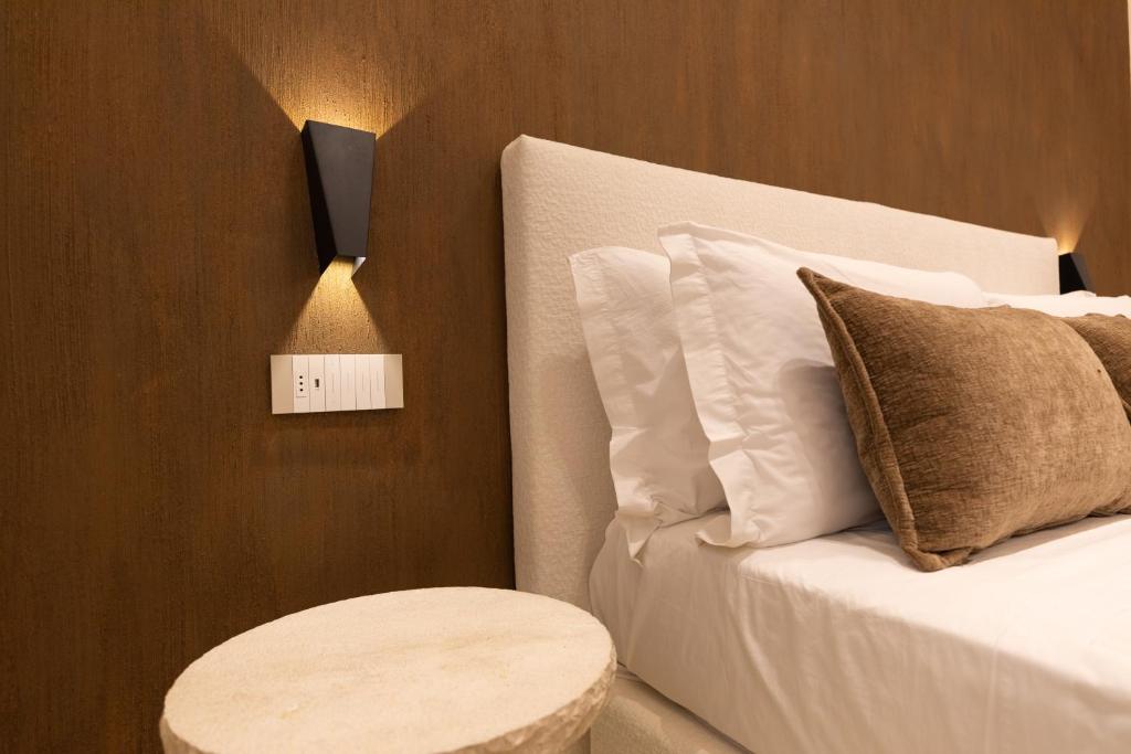 a bedroom with a bed with a table next to it at Double A Luxury Room in Olbia