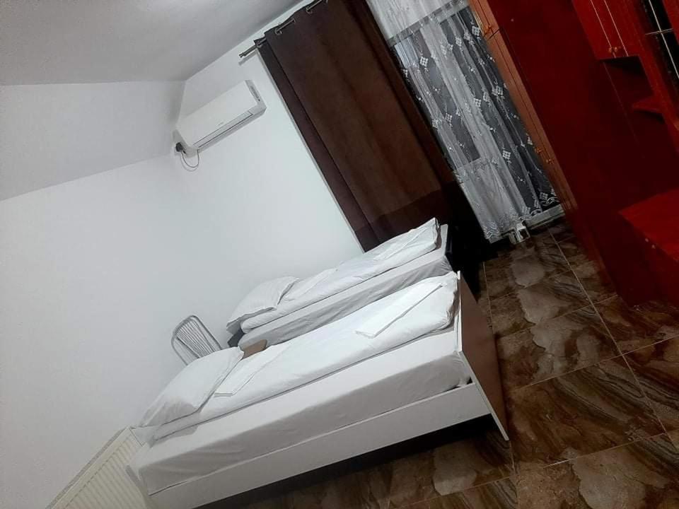 a room with a bed with white sheets at CASA ARDELEANULUI in Satu Mare