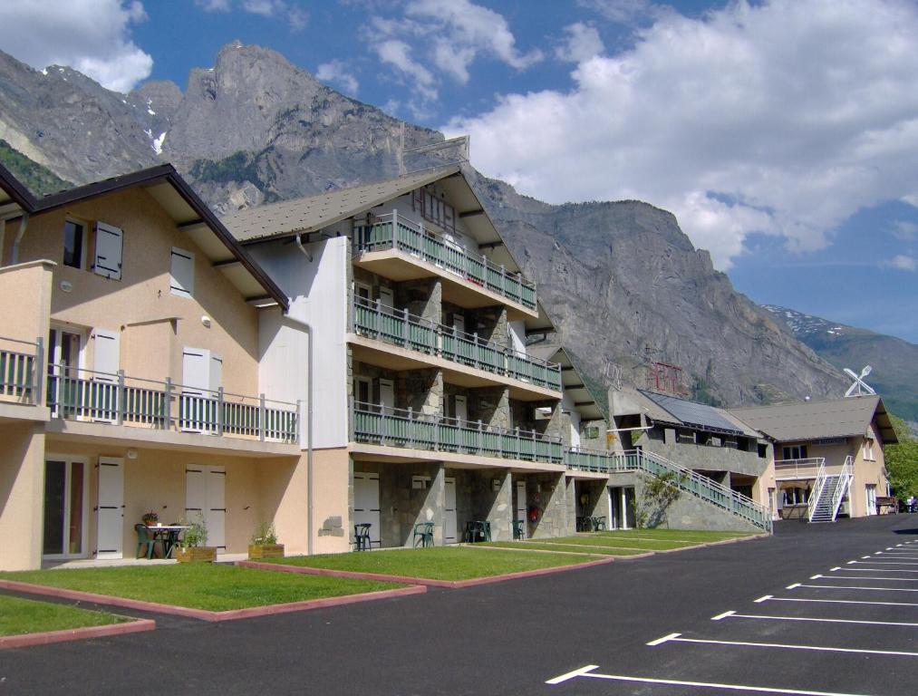 a large building with a mountain in the background at Hotel Restaurant Lancheton in Saint-Julien-Mont-denis