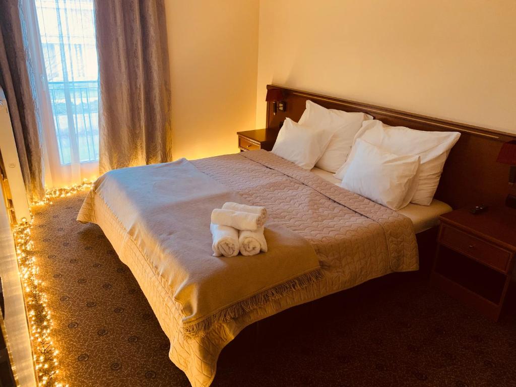um quarto de hotel com uma cama com duas toalhas em A01 Sétány-Silverine Apartmanház-Őrzött parkolóval em Balatonfüred
