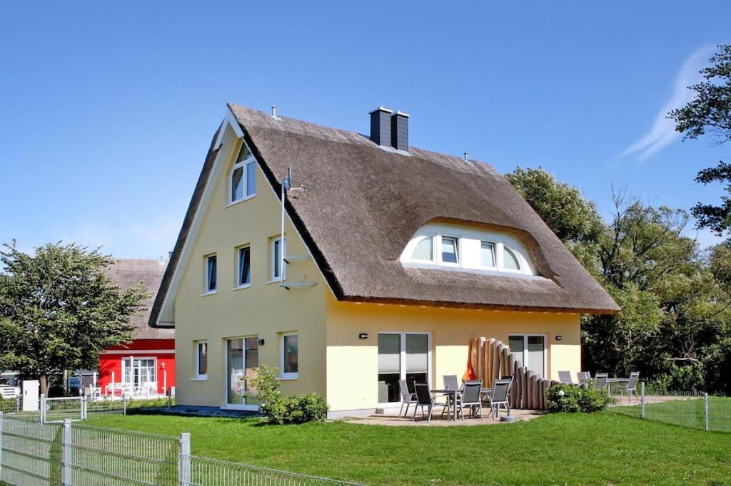 a yellow house with a thatched roof at Doppelhaushälfte Sprotte am Breetzer Bodden in Vieregge in Vieregge