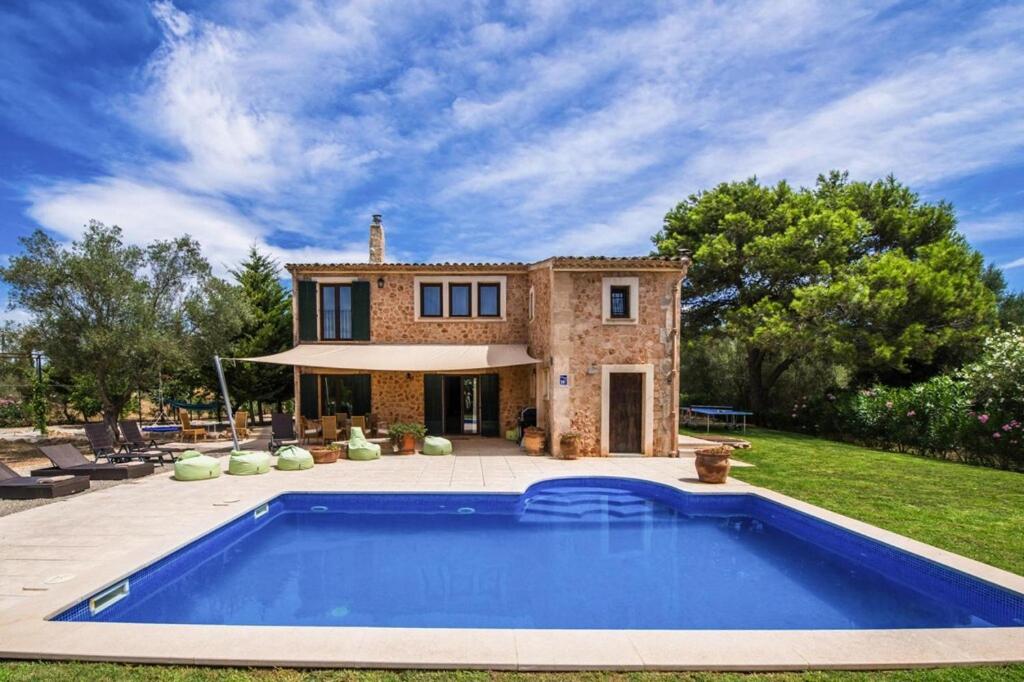 - une vue extérieure sur une maison avec une piscine dans l'établissement Finca Kiana in Santa Eugènia - your child-friendly holiday finca on Mallorca, à Sencelles