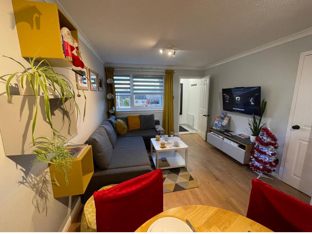 uma sala de estar com um sofá e uma televisão em Highfield apartment em Inverness