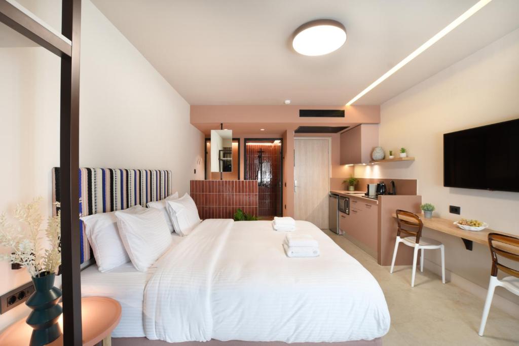Pavo Art Hotel في مدينة هيراكيلون: غرفة نوم مع سرير أبيض كبير ومكتب
