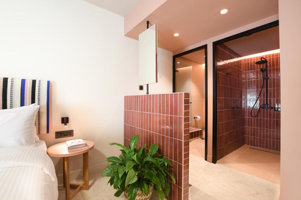 イラクリオン・タウンにあるPavo Art Hotelのベッドルーム1室(シャワー、ベッド1台、テーブル付)