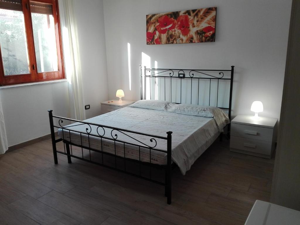 a bed in a bedroom with two night stands and two lamps at B & B La Magnolia in Specchiolla