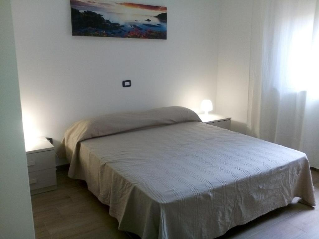 a bedroom with a bed and a painting on the wall at B & B La Magnolia in Specchiolla