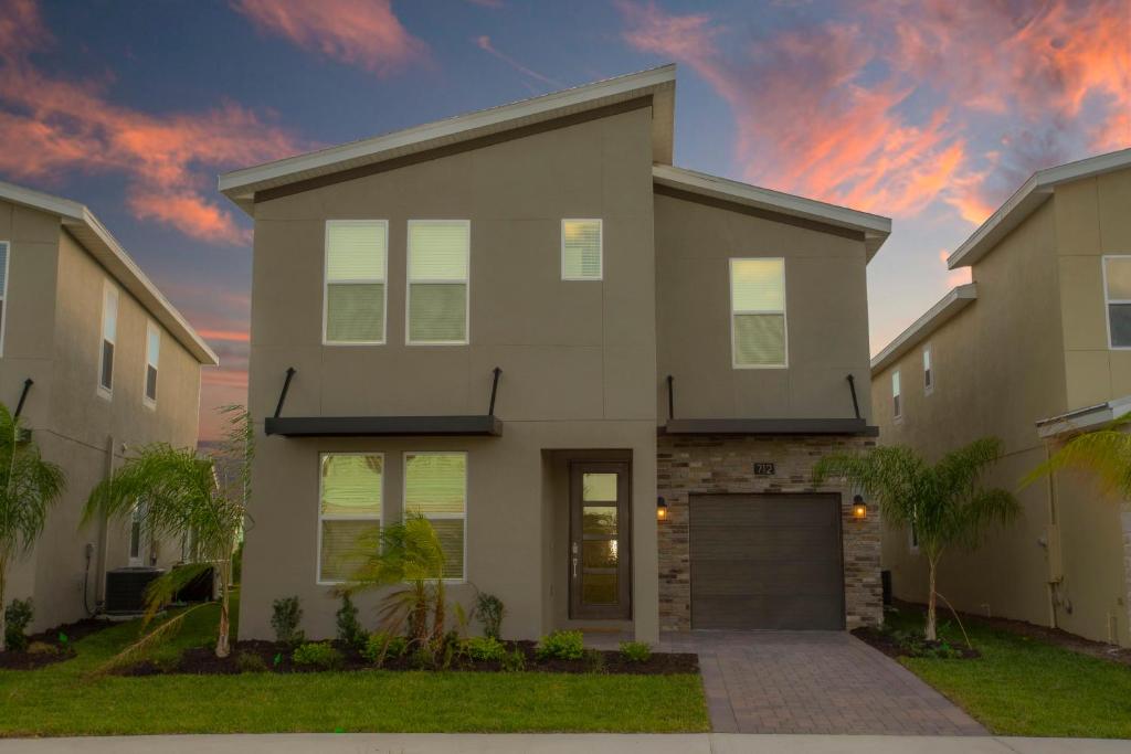 a house with a garage at sunset at Gorgeous 6 Bd SF Close to Disney w/ Pool @ Champions Gate Resort 712 in Kissimmee