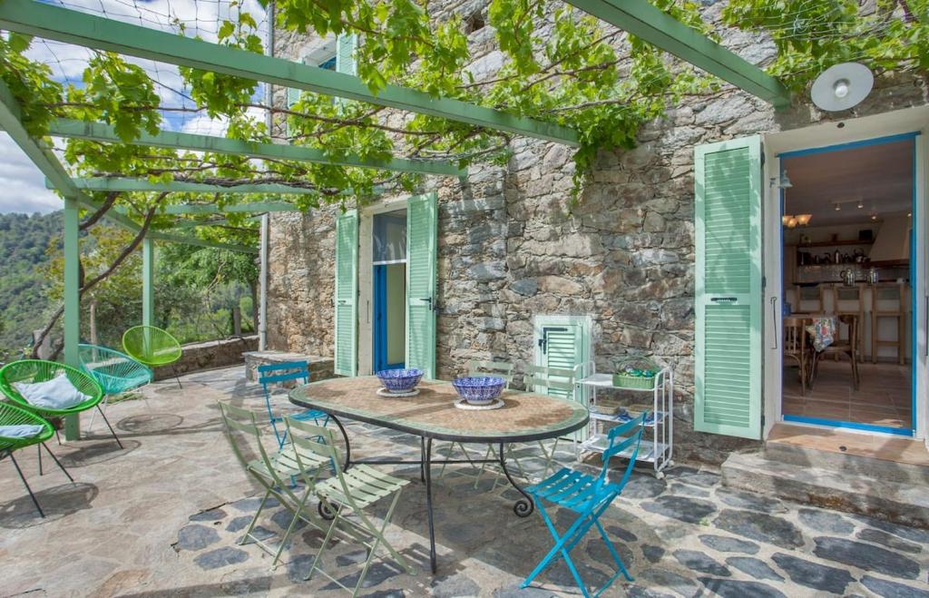 d'une terrasse avec une table et des chaises ainsi qu'un mur en pierre. dans l'établissement Beautiful stone house in the village of Poggio-di-Nazza, à Poggio-di-Nazza