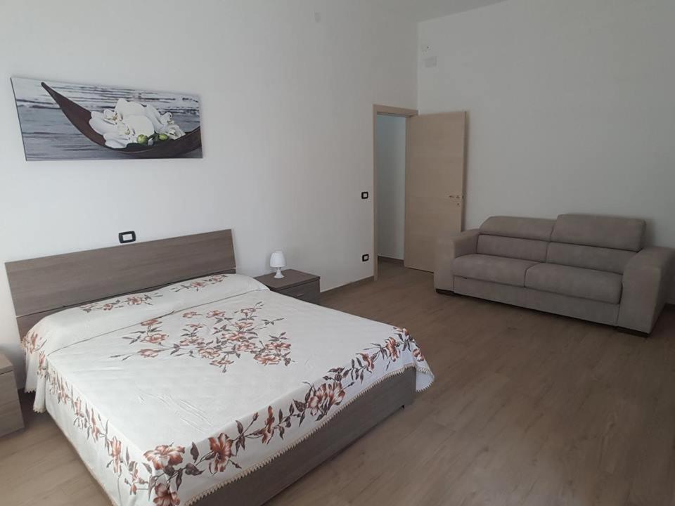 a bedroom with a bed and a couch at B & B La Magnolia in Specchiolla