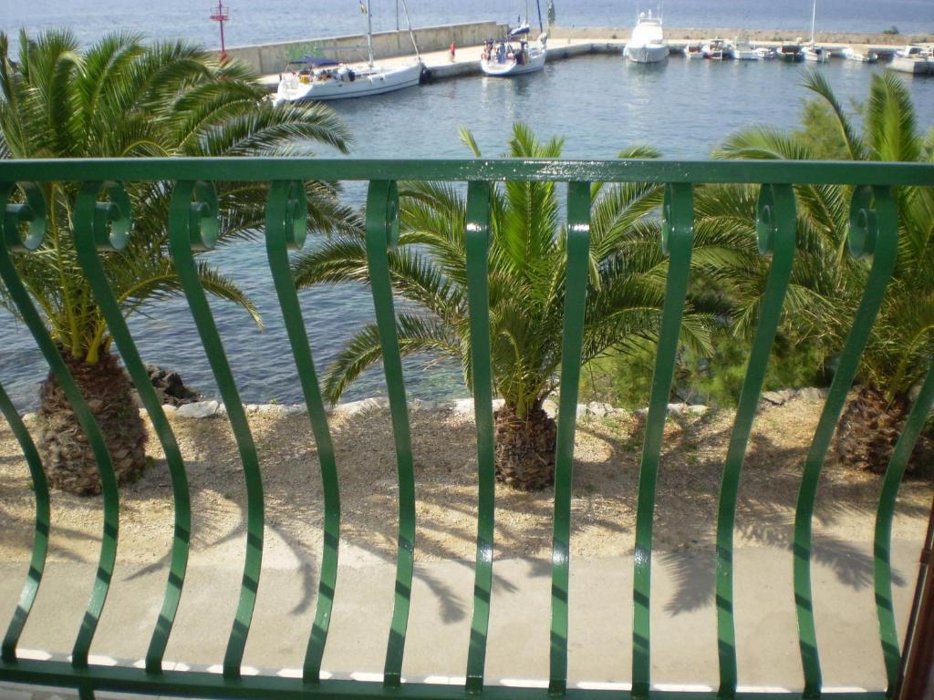a balcony with palm trees and a marina at Apartment Smil - 30 m from sea in Sućuraj