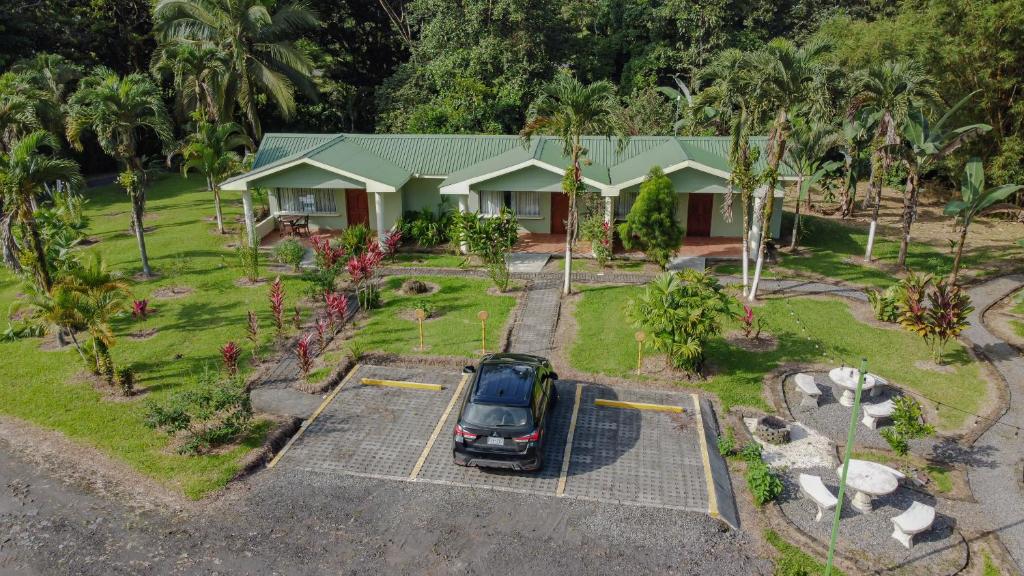 an aerial view of a house with a car parked in a parking lot at Confort Arenal in Fortuna