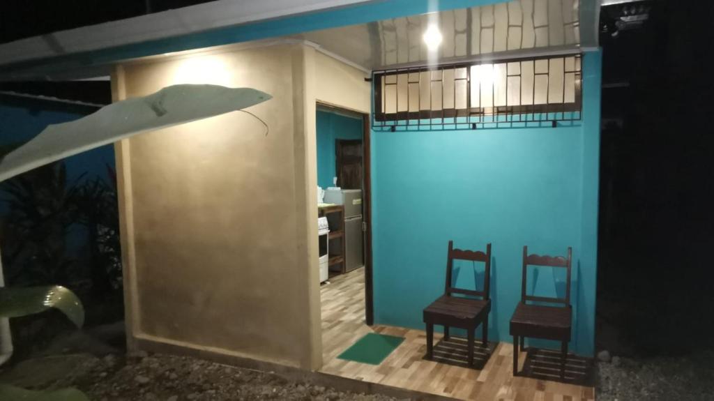 Habitación con 2 sillas y pared azul en Manta Ray's Cahuita Apart. en Cahuita