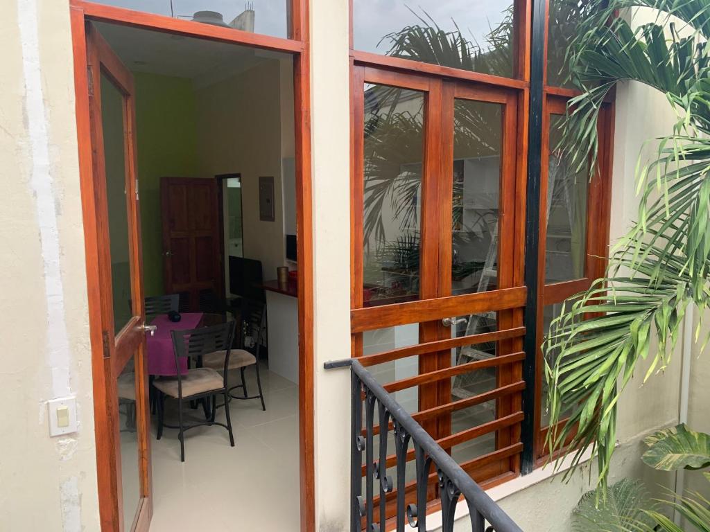 una porta aperta su un balcone con tavolo e sedie di apartamentos Casa Amarilla a Granada