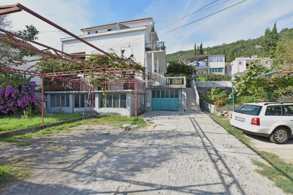 a house with a car parked in front of it at Apartments Kujacic in Herceg-Novi