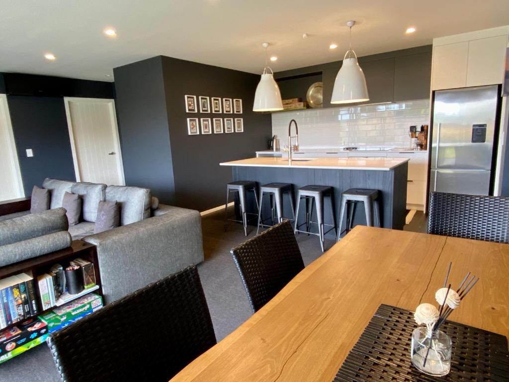 a kitchen and living room with a wooden table and chairs at Mountain Vista Retreat - Apartment 2 in Twizel