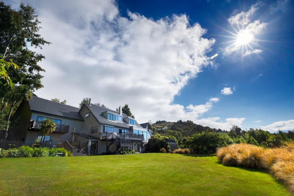 a house with a large lawn in front of it at Hidden Lodge Queenstown in Queenstown