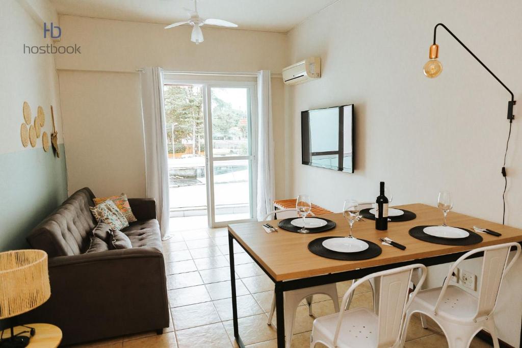 uma sala de estar com uma mesa e um sofá em Apto a 200 m da praia do bosque - WIFI 200MB - TV Smart - Cozinha equipada - Garagem - Ar condicionado em Rio das Ostras
