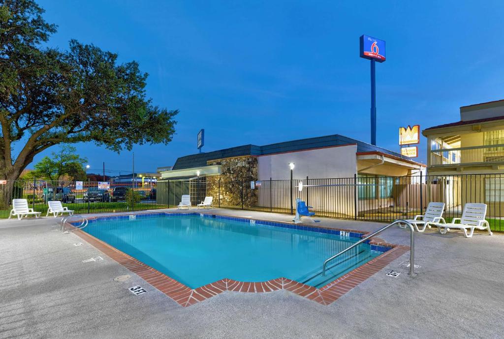 a swimming pool in a parking lot next to a building at Studio 6-Denton, TX - UNT in Denton