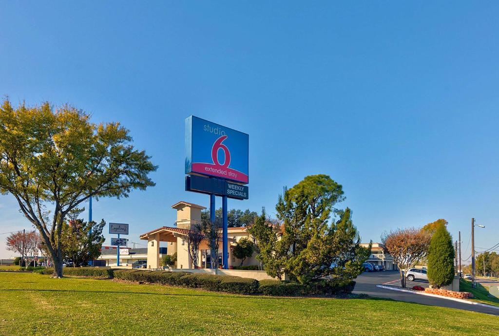a gas station sign in front of a building at Studio 6-Denton, TX - UNT in Denton
