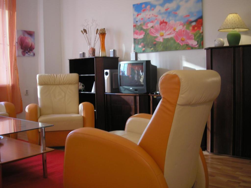 a living room with two chairs and a tv at Vacation Apartment up to 10 in Bratislava