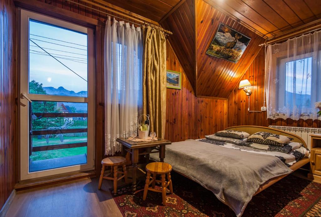 ein Schlafzimmer mit einem Bett und einem großen Fenster in der Unterkunft Pokoje u Sarnowskich in Kościelisko