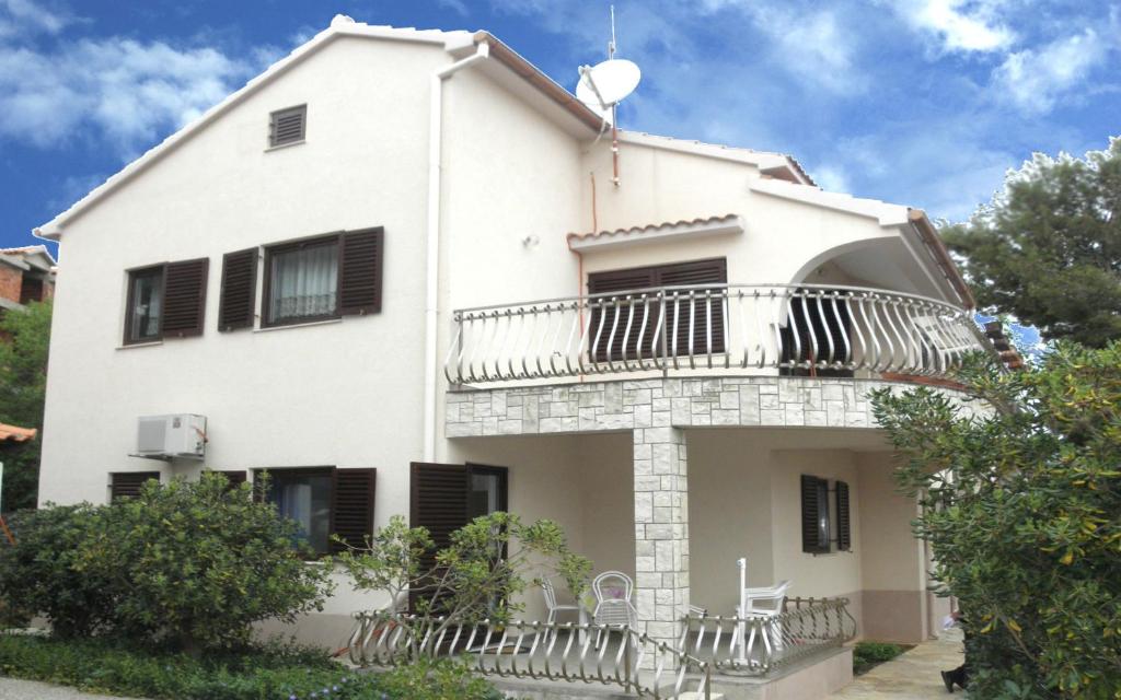 a white house with a balcony on top of it at Apartments Ruzica - 50 m from sea in Jezera