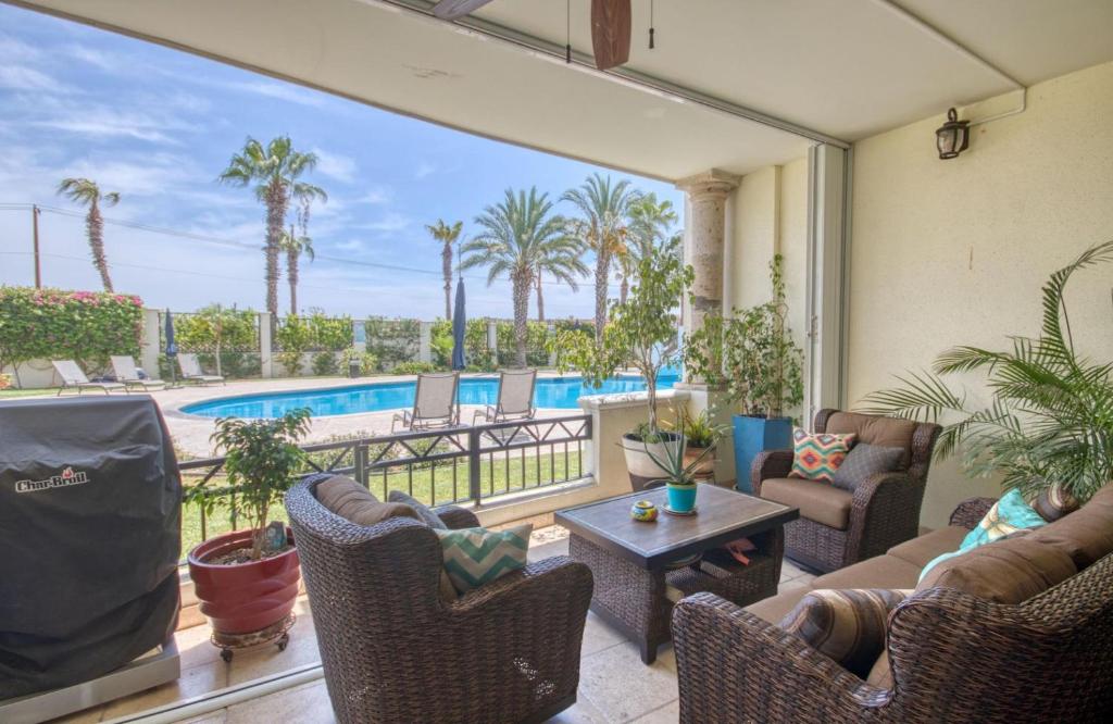 a living room with a view of a swimming pool at Perfect location - Puerta Cabo Village 500 steps to the beach & resorts in Cabo San Lucas