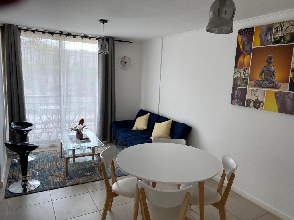 sala de estar con mesa blanca y sofá azul en Departamento Ciudad de Caldera, Bahia Inglesa en Caldera