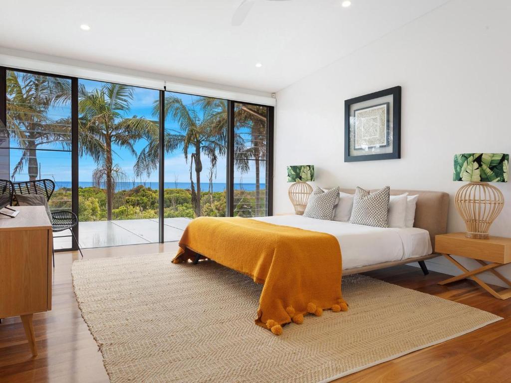 a bedroom with a bed with a view of the ocean at Kiah - nestled between Main & Belongil Beaches in Byron Bay