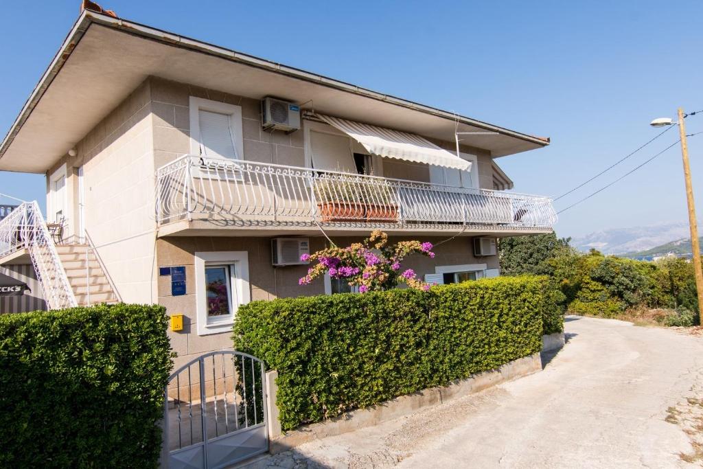 una casa con balcone e alcuni cespugli di Apartments Ivica - garden terrace a Slatine