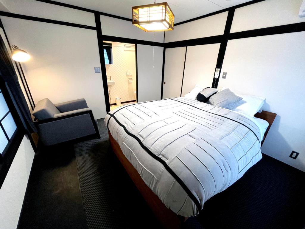 Un dormitorio con una cama grande y una ventana en Nozawa Onsen BASECAMP en Nozawa Onsen