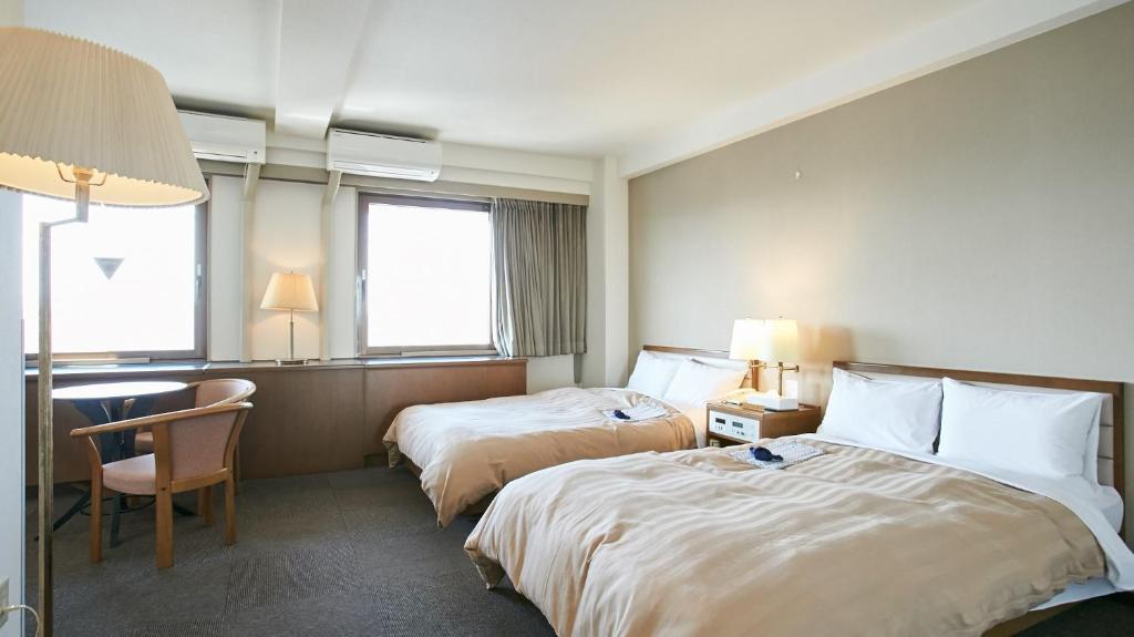 Säng eller sängar i ett rum på Kanku Sun Plus Yutaka