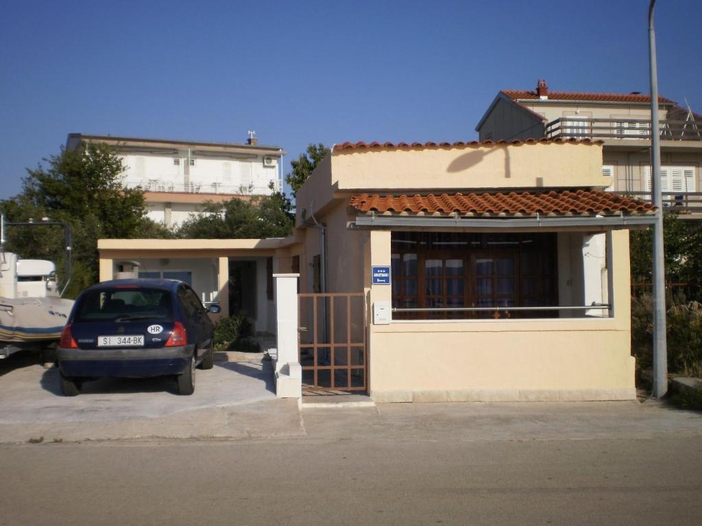 a car parked in a parking lot in front of a house at Apartments Vito - 10 m from sea in Brodarica