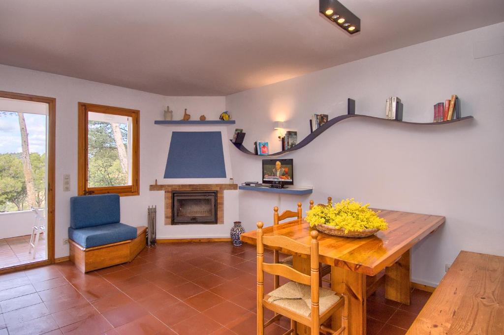 ein Wohnzimmer mit Tisch und Kamin in der Unterkunft Sa Tuna "Casas CE MA" in Begur