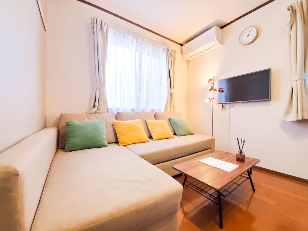 a living room with a couch and a table at nestay suite tokyo shibuya in Tokyo