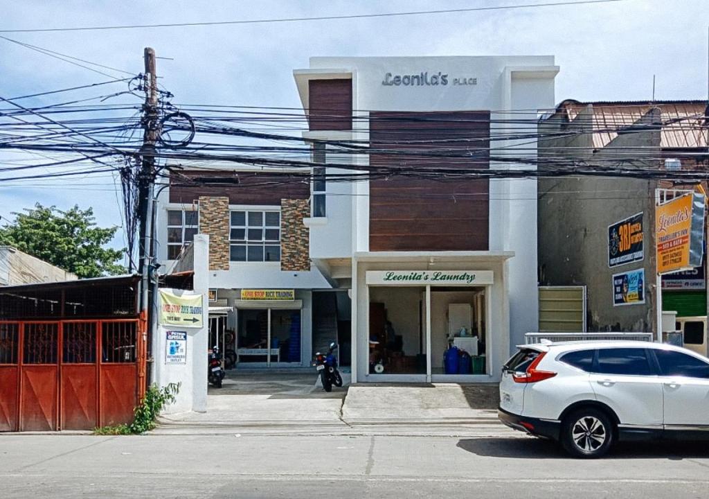 a white car parked in front of a building at Leonila's Travellers Inn in Iloilo City